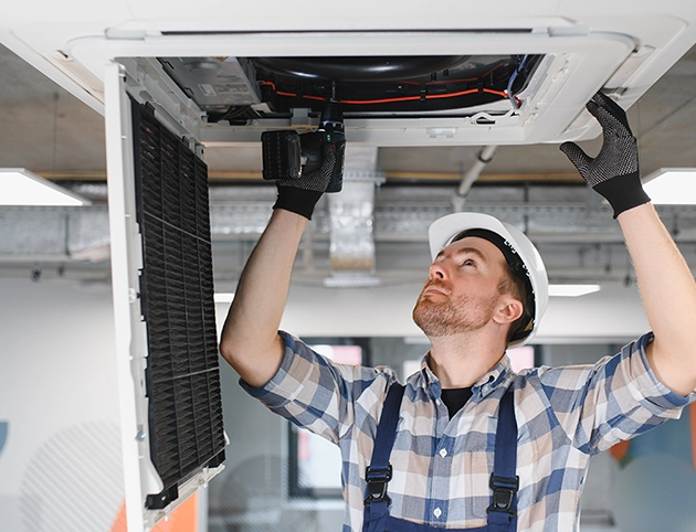 Instalador profesional montando un aire acondicionado cassette CoolSmart